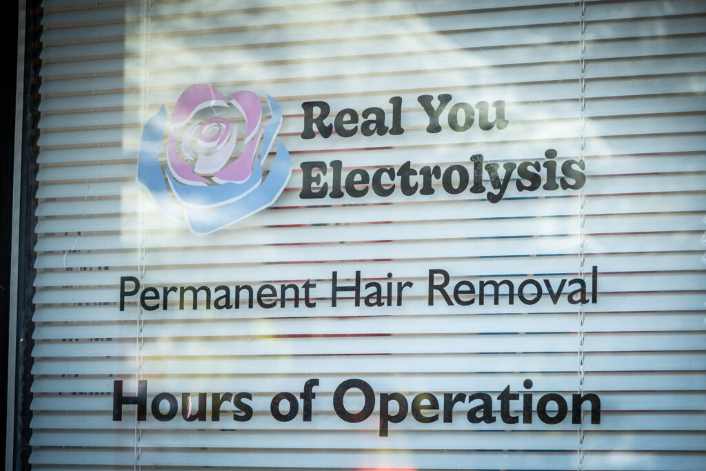 A picture of a Real You Electrolysis sign in a window.