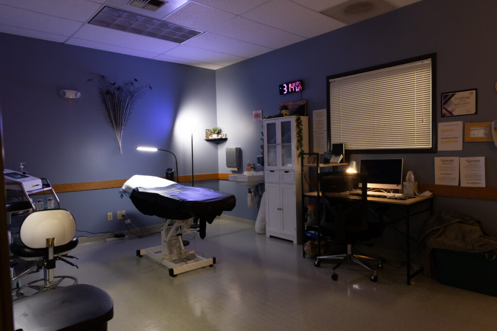 One of our electrolysis treatment rooms at our Vancouver WA office. There are multiple lights and peacock feathers on the blue walls.