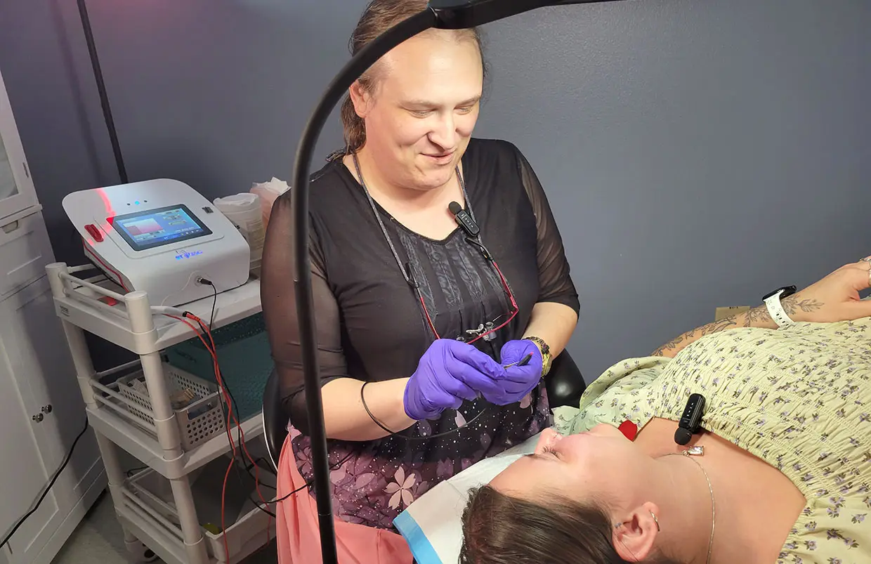 Electrologist showing hair removal to electrolysis client
