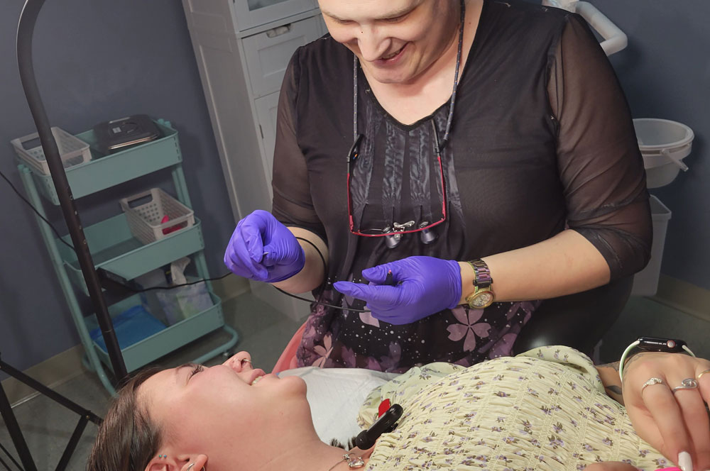 Electrolysis hair removal client with electrologist, during epilation treatment.